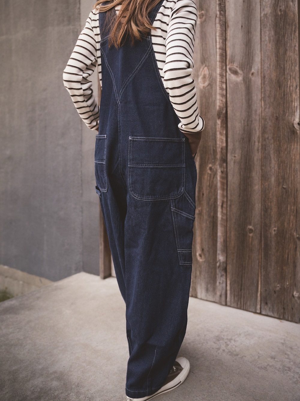 ブラウン系のTシャツ/カットソー、レッド系のニット/セーター、ブルー系のサロペット/オーバーオールを着用したレディースの冬コーディネートの4枚目の写真