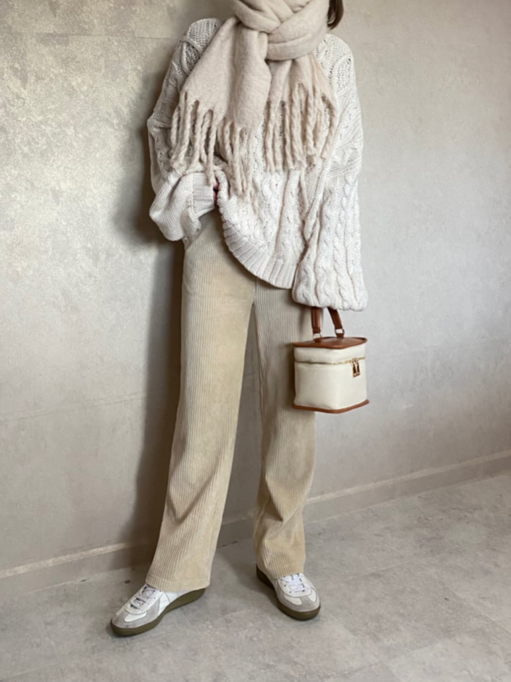 ベージュ系のニット/セーター、ホワイト系のその他パンツ、ホワイト系のスニーカーを着用したレディースの冬コーディネートの2枚目の写真