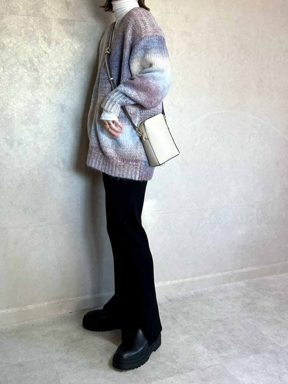 ブルー系のカーディガン/ボレロ、ホワイト系のショルダーバッグ、ブラック系のその他パンツを着用したレディースの冬コーディネートの2枚目の写真