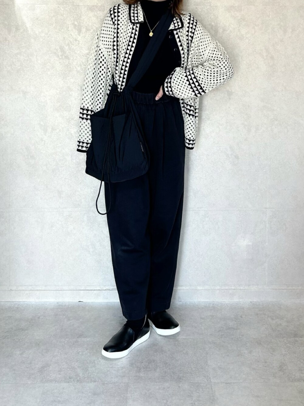 ホワイト系のカーディガン/ボレロ、ブラック系のボディバッグ/ウエストポーチを着用したレディースの秋コーディネートの2枚目の写真
