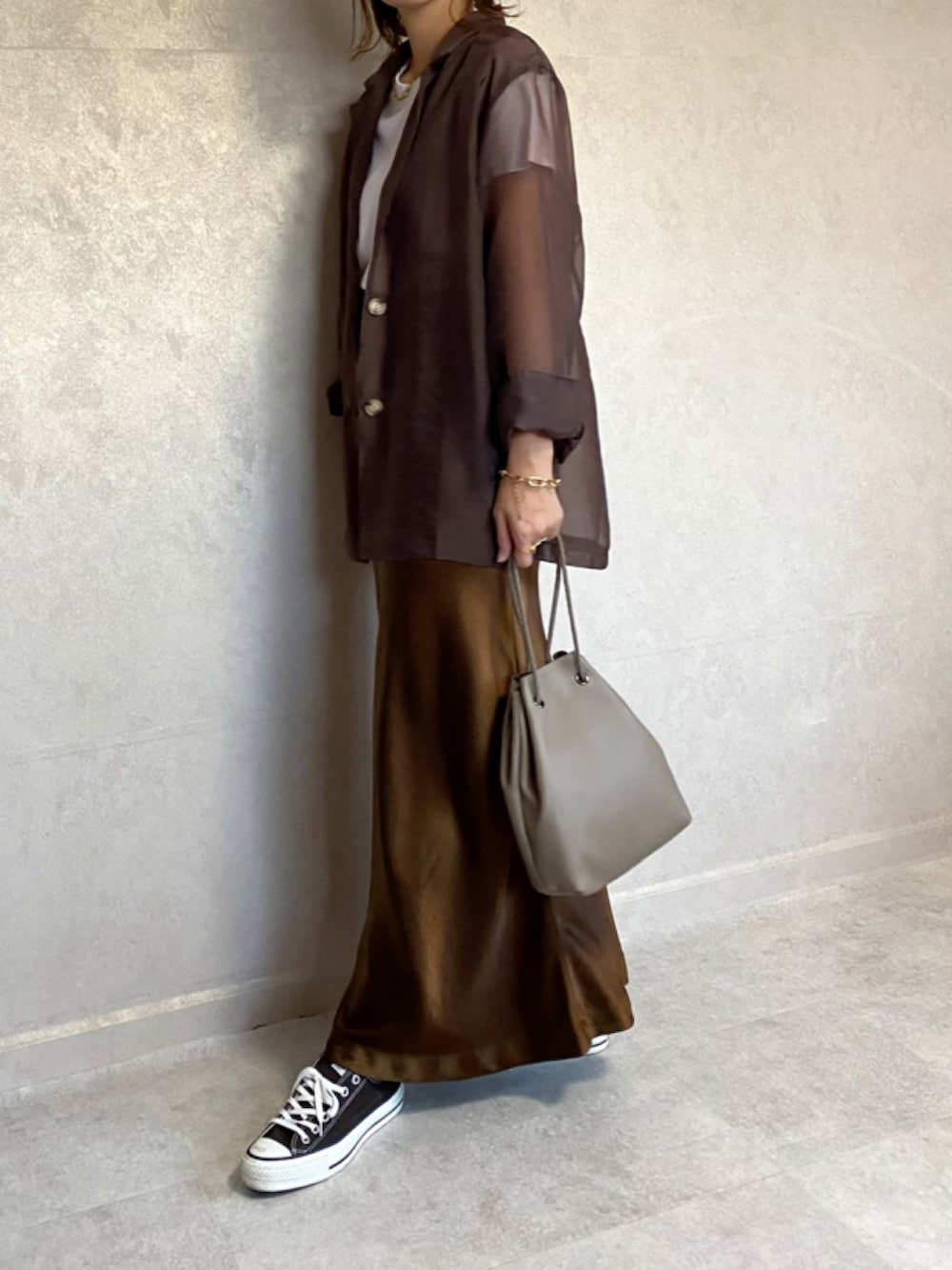 ブラウン系のテーラードジャケット、ブラウン系のスカート、ベージュ系のショルダーバッグを着用したレディースの秋コーディネートの2枚目の写真