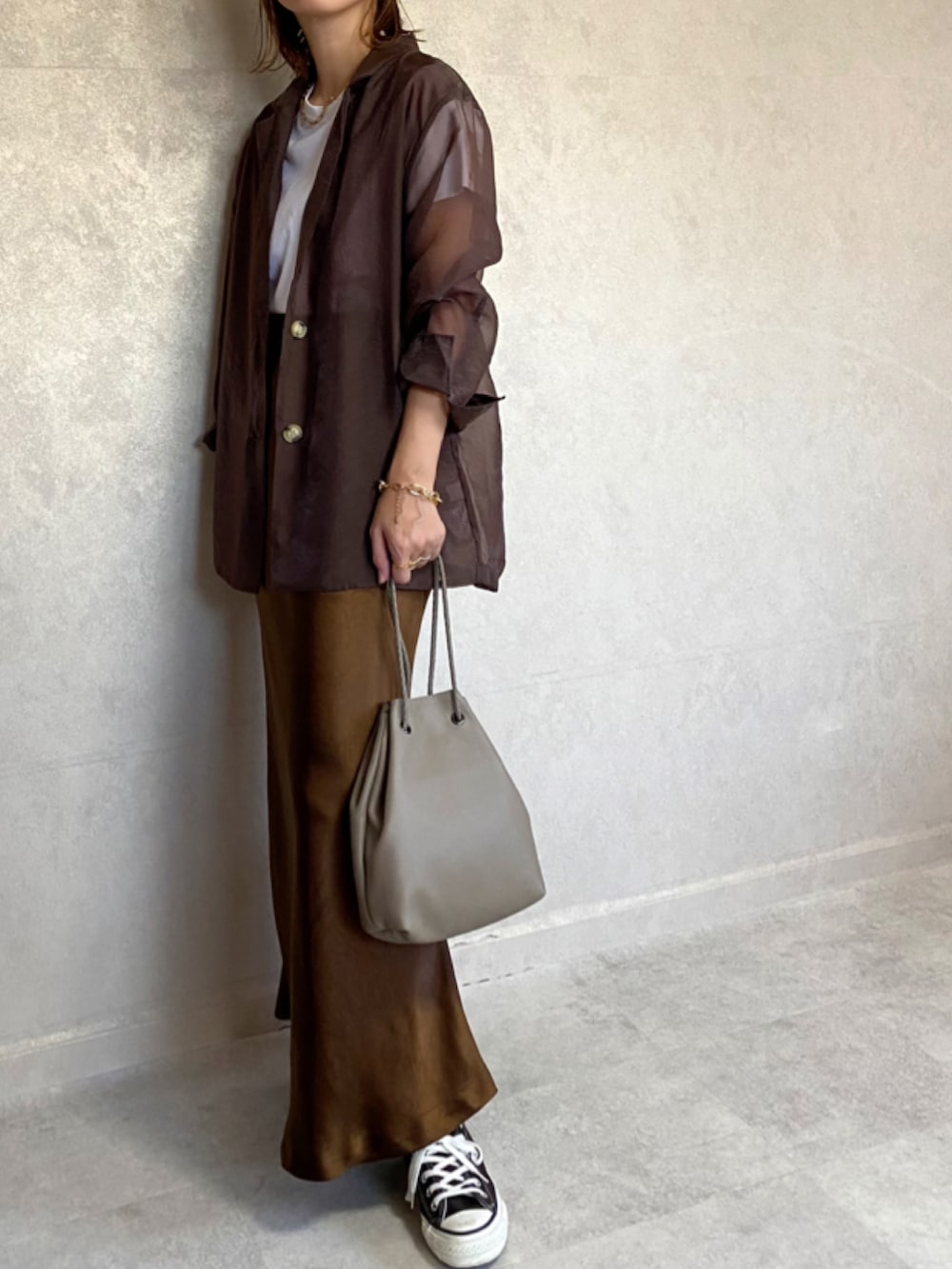 ブラウン系のテーラードジャケット、ブラウン系のスカート、ベージュ系のショルダーバッグを着用したレディースの秋コーディネートの3枚目の写真