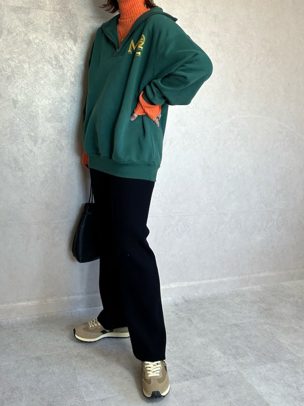 グリーン系のスウェット、オレンジ系のニット/セーター、ブラック系のショルダーバッグを着用したレディースの秋コーディネートの2枚目の写真