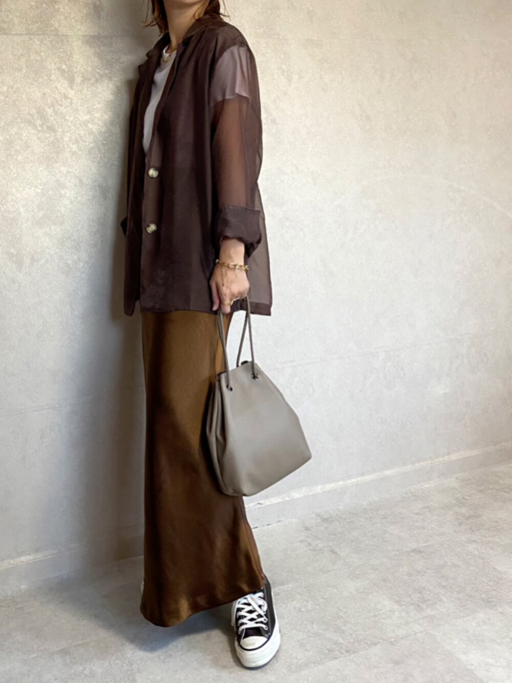 ブラウン系のテーラードジャケット、ブラウン系のスカート、ベージュ系のショルダーバッグを着用したレディースの秋コーディネートの4枚目の写真
