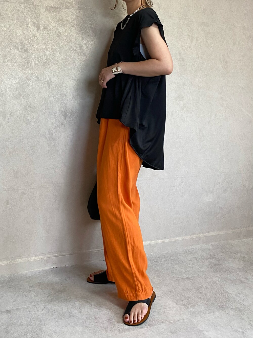 「ECRIRE、ECRIRE×miho.a.nico、エクリール、コラボ、コラボレーション、コラボ商品、コラボアイテム、vitafelice、巾着バッグ、レザーバッグ、オレンジ、オレンジコーデ、オレンジパンツ、トングサンダル、レザーサンダル」｜「ECRIREの【miho.a.nicoコラボ】タックデザインノースリーブカットソーブラウス（シャツ/ブラウス、ブラック系）」を使った、miho🅰ニコさん（レディース・165cm）の夏コーディネートの4枚目の写真