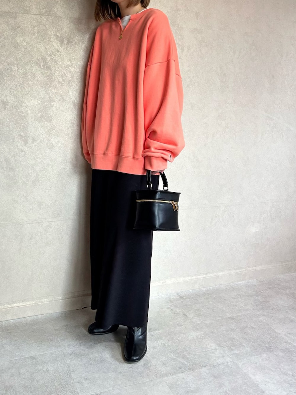 オレンジ系のスウェット、ブラック系のショルダーバッグを着用したレディースの春コーディネートの4枚目の写真