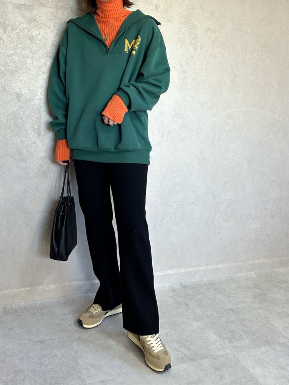 グリーン系のスウェット、オレンジ系のニット/セーター、ブラック系のショルダーバッグを着用したレディースの秋コーディネートの4枚目の写真