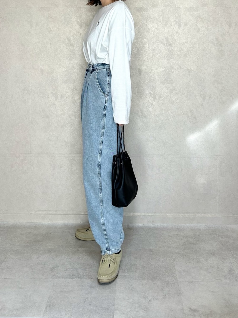 ホワイト系のTシャツ/カットソー、ブルー系のデニムパンツ、ベージュ系のモカシン/デッキシューズを着用したレディースの春コーディネートの2枚目の写真