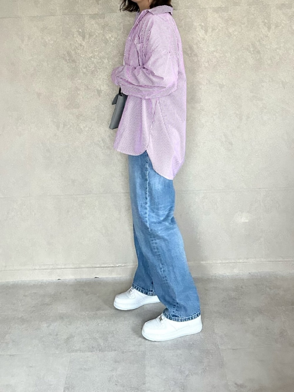 ピンク系のシャツ/ブラウス、グレー系のバッグ、ホワイト系のTシャツ/カットソーを着用したレディースの春コーディネートの3枚目の写真