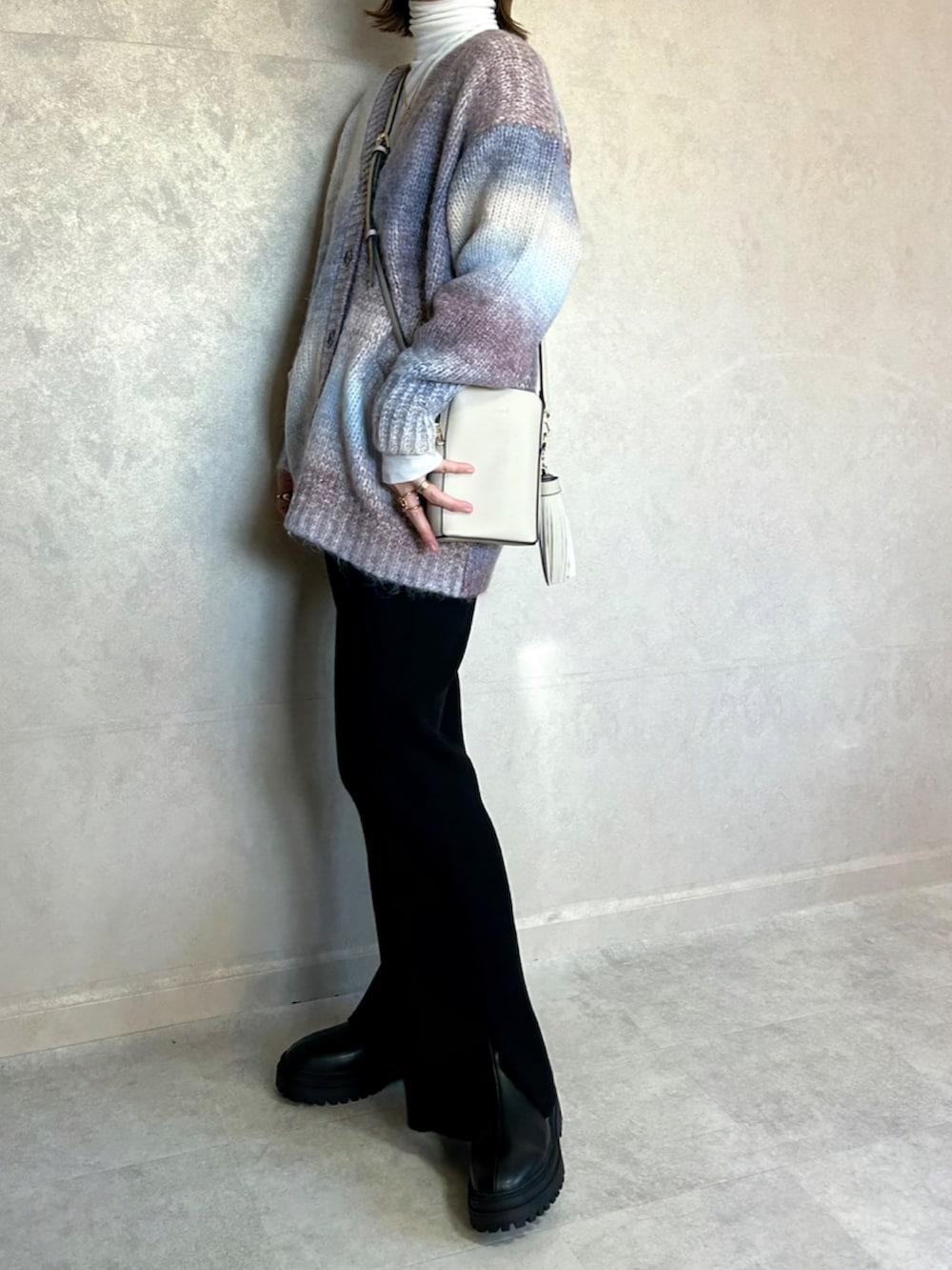 ブルー系のカーディガン/ボレロ、ホワイト系のショルダーバッグ、ブラック系のその他パンツを着用したレディースの冬コーディネートの4枚目の写真