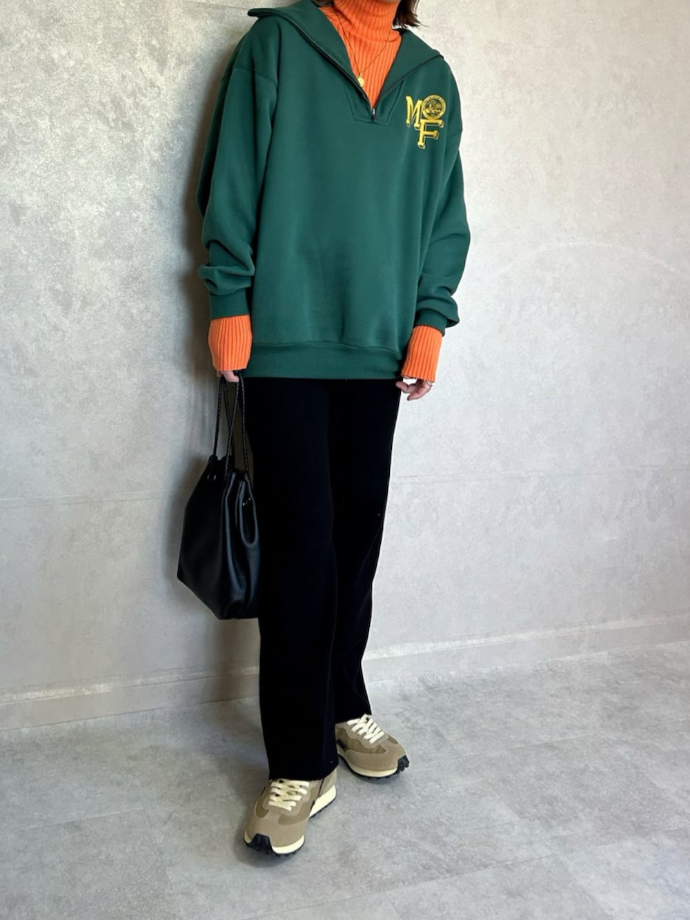 グリーン系のスウェット、オレンジ系のニット/セーター、ブラック系のショルダーバッグを着用したレディースの秋コーディネートの5枚目の写真