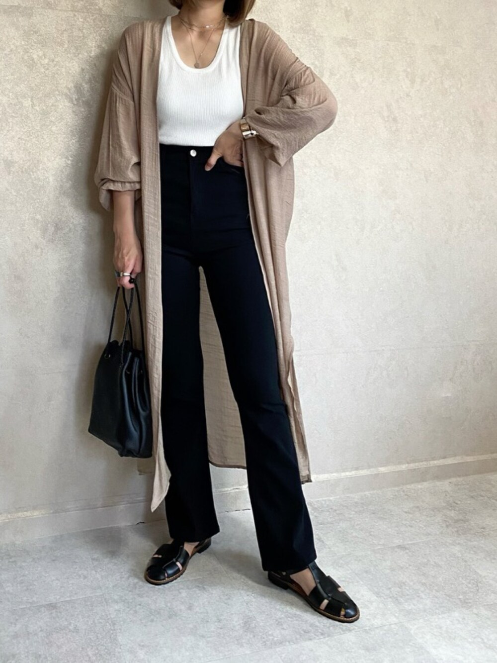 ベージュ系のカーディガン/ボレロ、ホワイト系のタンクトップ、ブラック系のその他パンツを着用したレディースの春コーディネートの2枚目の写真