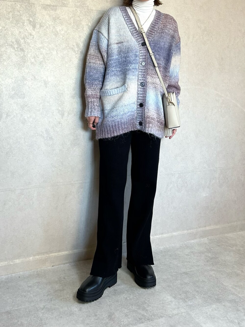 ブルー系のカーディガン/ボレロ、ホワイト系のショルダーバッグ、ブラック系のその他パンツを着用したレディースの冬コーディネートの3枚目の写真