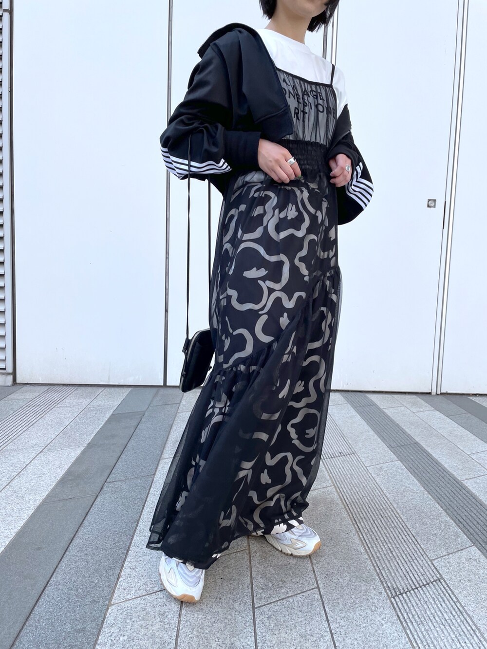 ブラック系のワンピース、ホワイト系のスニーカーを着用したレディースの春コーディネートの4枚目の写真