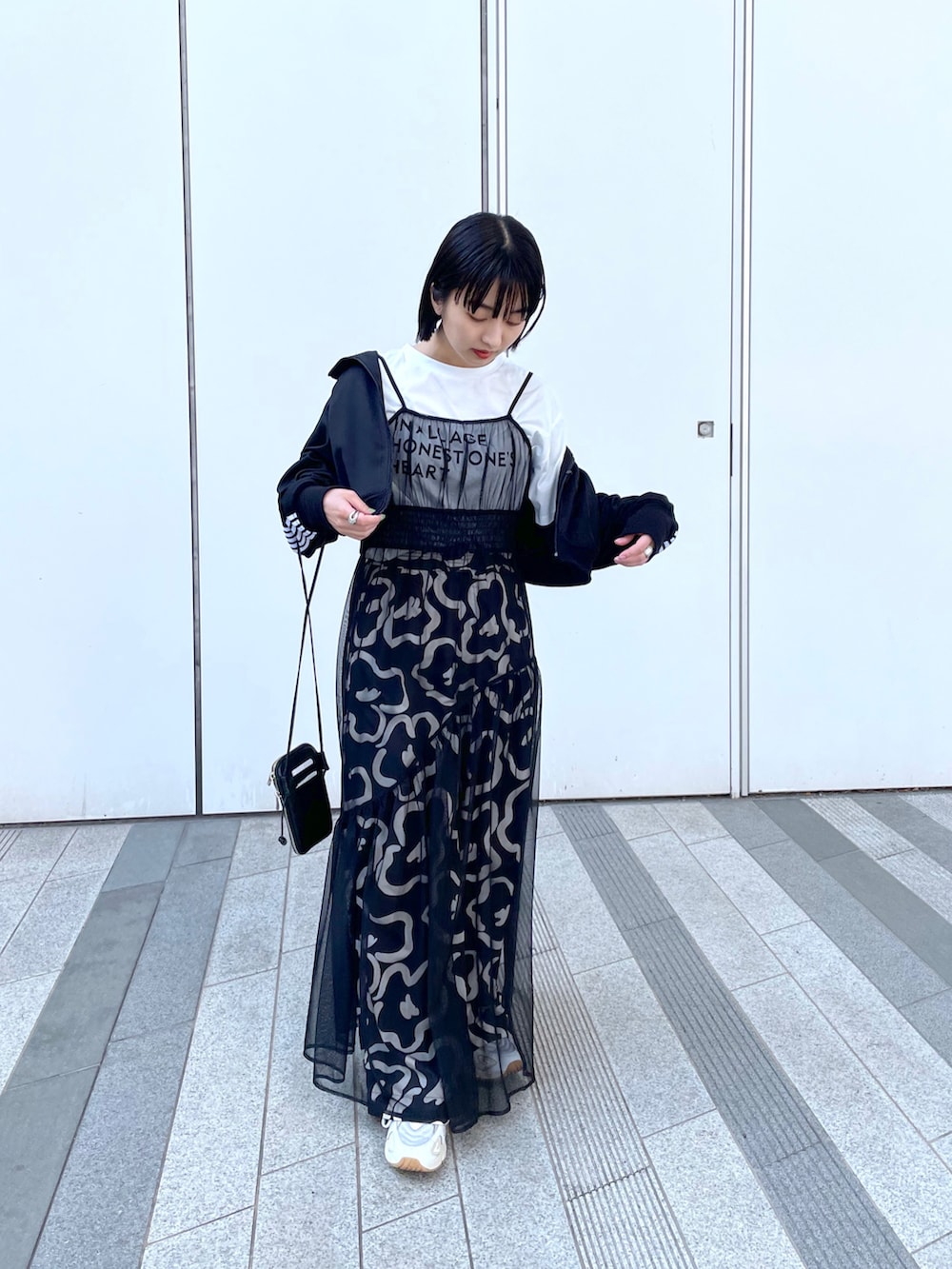 ブラック系のワンピース、ホワイト系のスニーカーを着用したレディースの春コーディネートの3枚目の写真