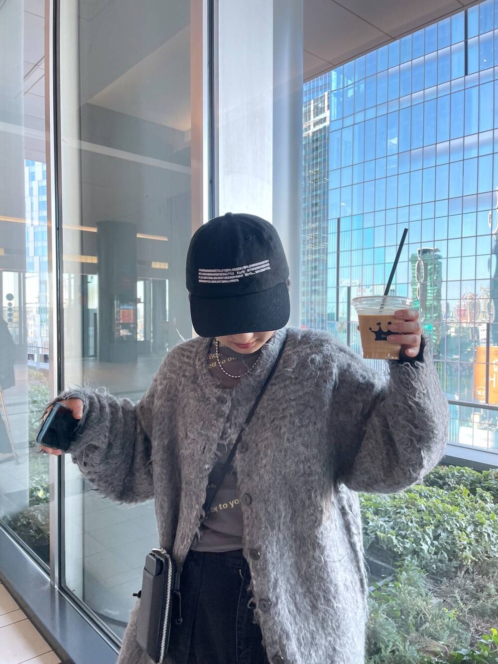 グレー系のTシャツ/カットソー、グレー系のカーディガン/ボレロ、ブラック系のデニムパンツを着用したレディースの冬コーディネートの3枚目の写真