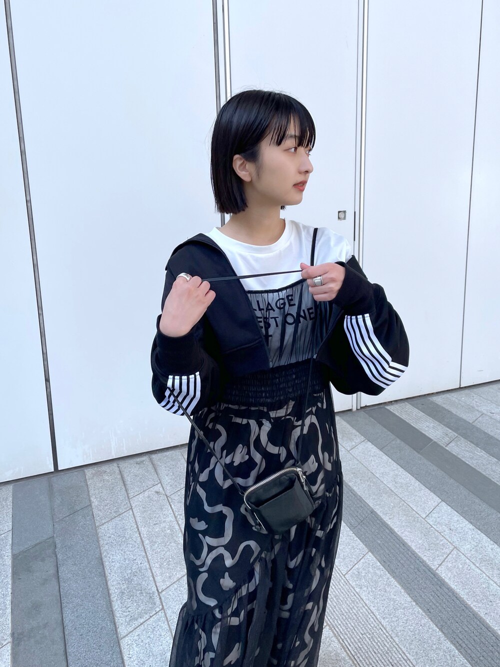 ブラック系のワンピース、ホワイト系のスニーカーを着用したレディースの春コーディネートの5枚目の写真