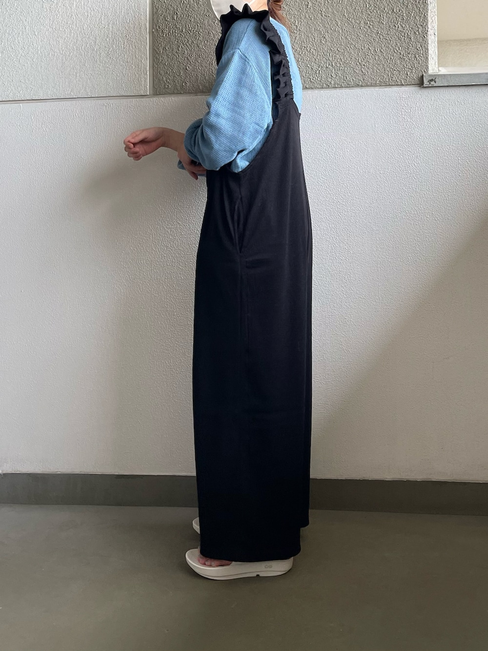 ブラック系のサロペット/オーバーオール、ブルー系のTシャツ/カットソー、ホワイト系のサンダルを着用したレディースの春コーディネートの2枚目の写真