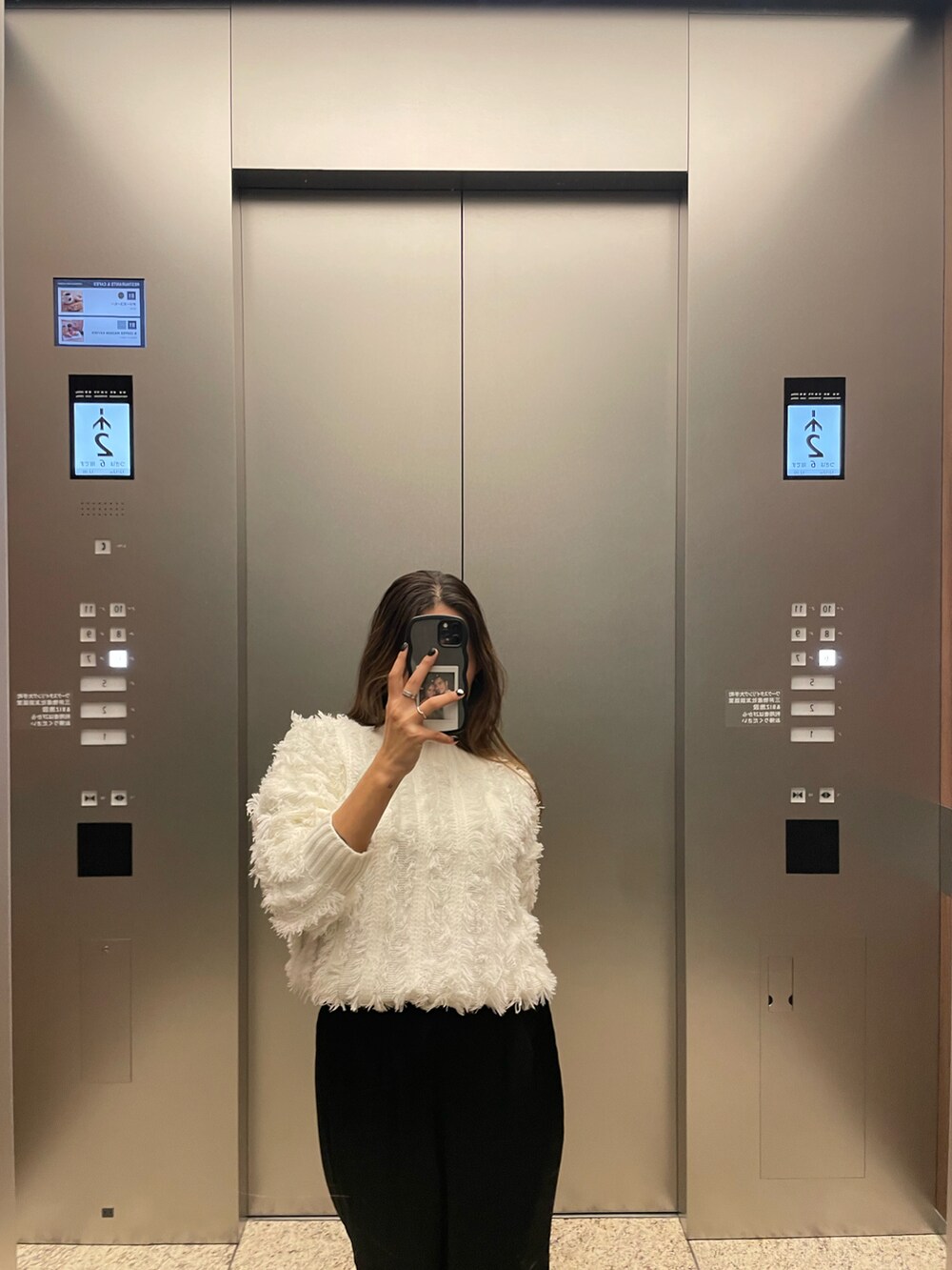 ブラック系のブーツ、ブラック系のスカートを着用したレディースの冬コーディネートの2枚目の写真