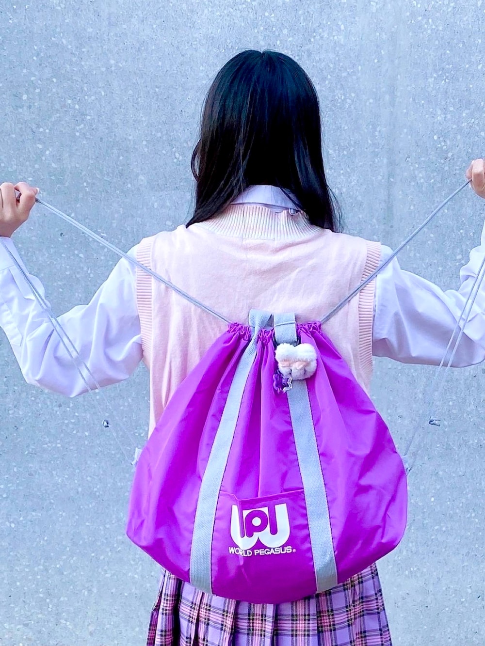 パープル系のバックパック/リュック、ホワイト系のスニーカー、ピンク系のファッション雑貨を着用したレディースの冬コーディネートの2枚目の写真