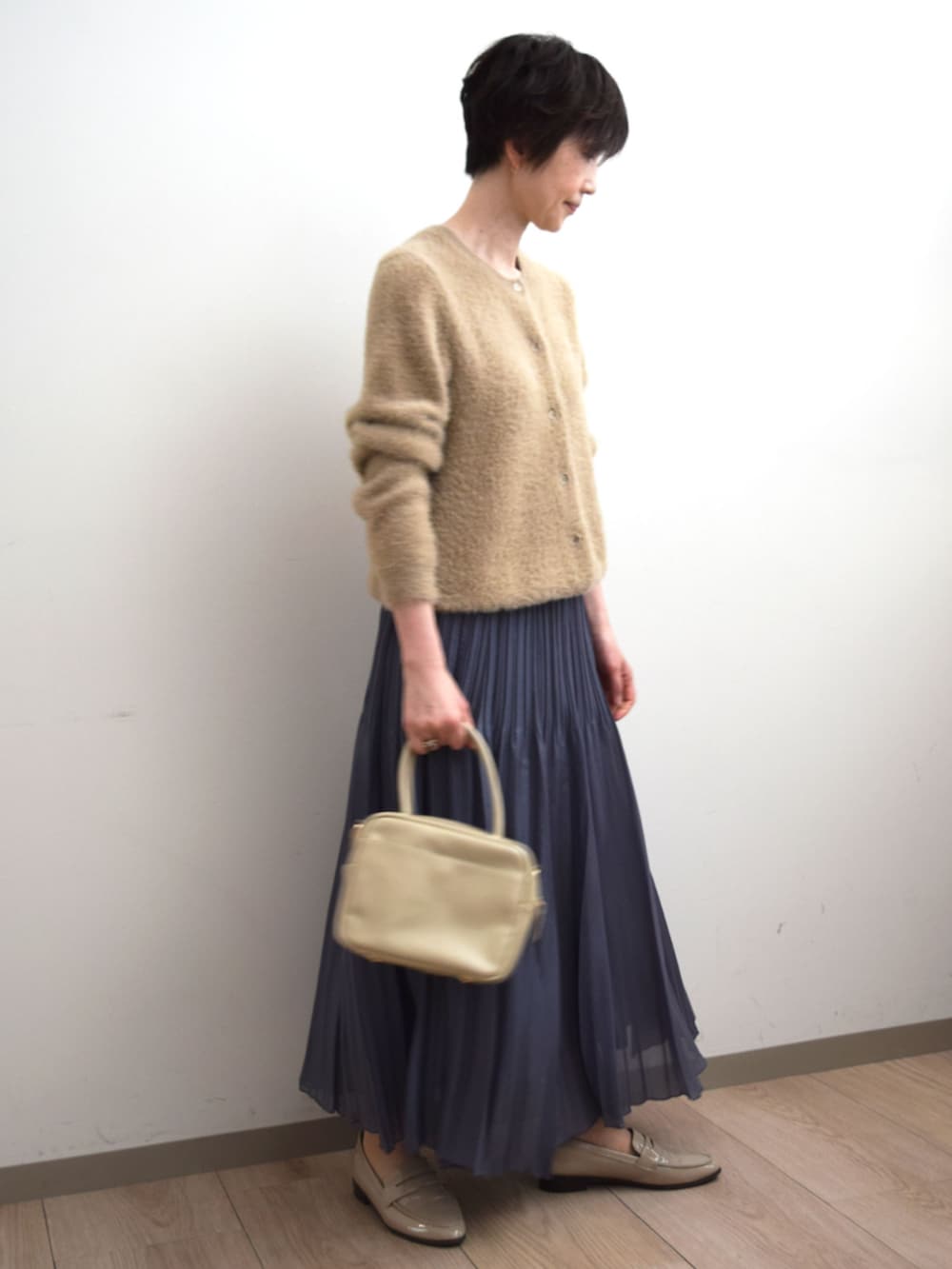グレー系のスカート、ベージュ系のカーディガン/ボレロを着用したレディースの秋コーディネートの4枚目の写真
