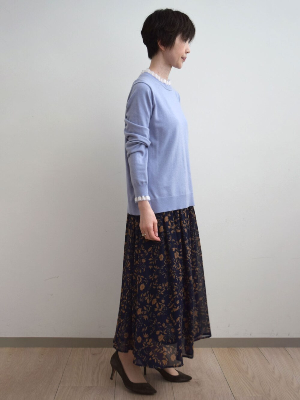 ブルー系のスカート、パープル系のニット/セーターを着用したレディースの秋コーディネートの2枚目の写真