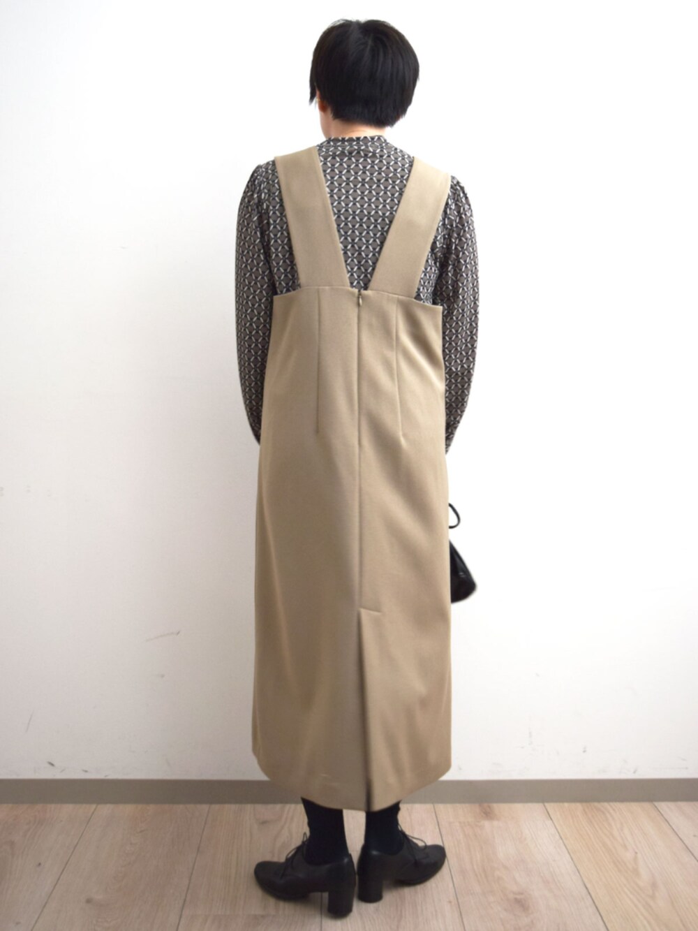 ベージュ系のジャンパースカート、ブラウン系のTシャツ/カットソーを着用したレディースの秋コーディネートの3枚目の写真