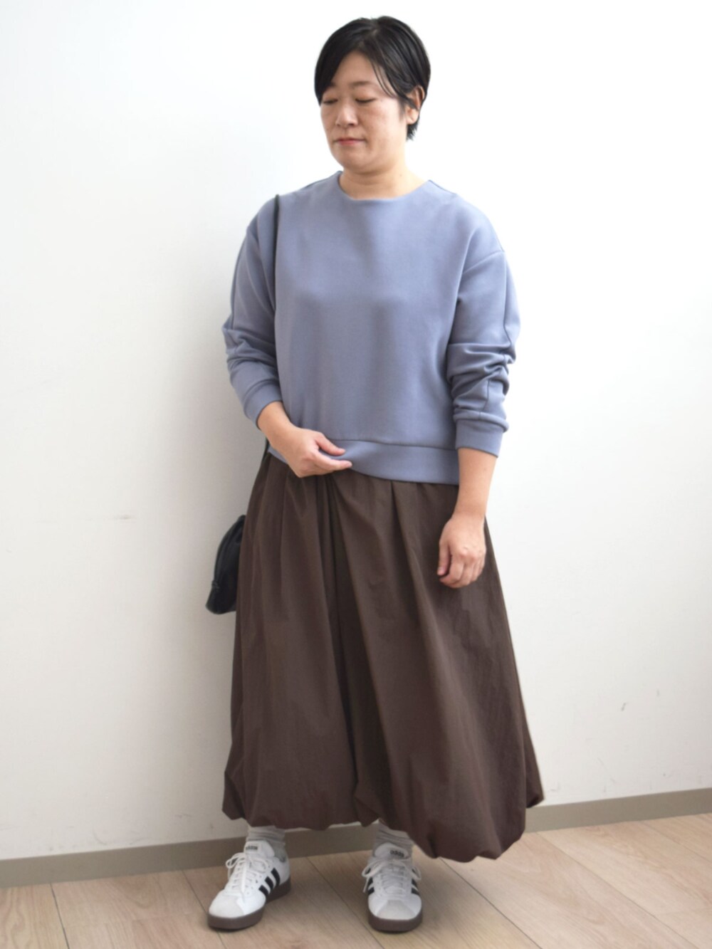 ブラウン系のスカート、ブルー系のスウェットを着用したレディースの秋コーディネートの4枚目の写真