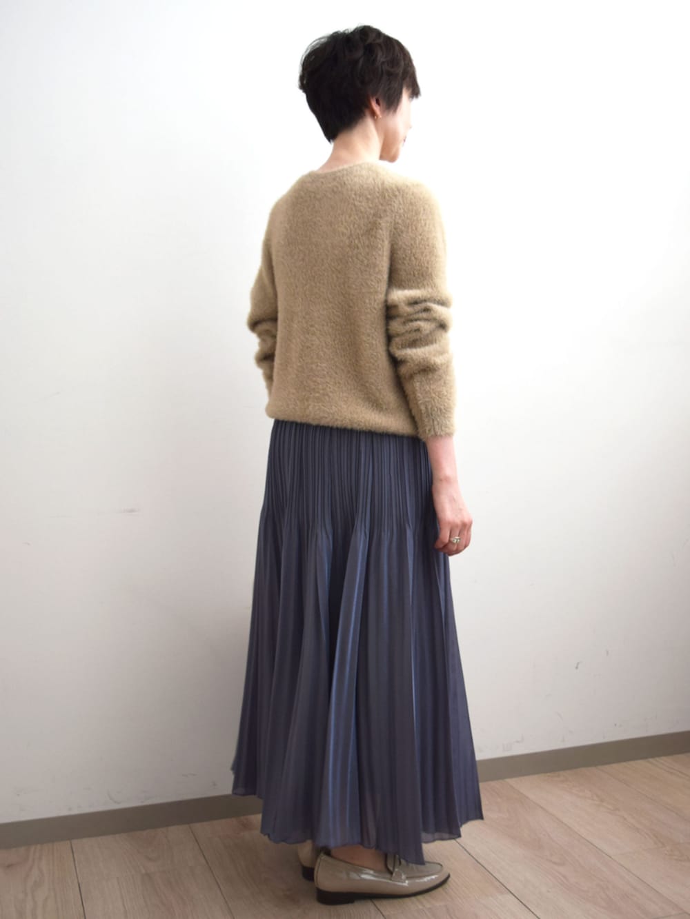 グレー系のスカート、ベージュ系のカーディガン/ボレロを着用したレディースの秋コーディネートの3枚目の写真