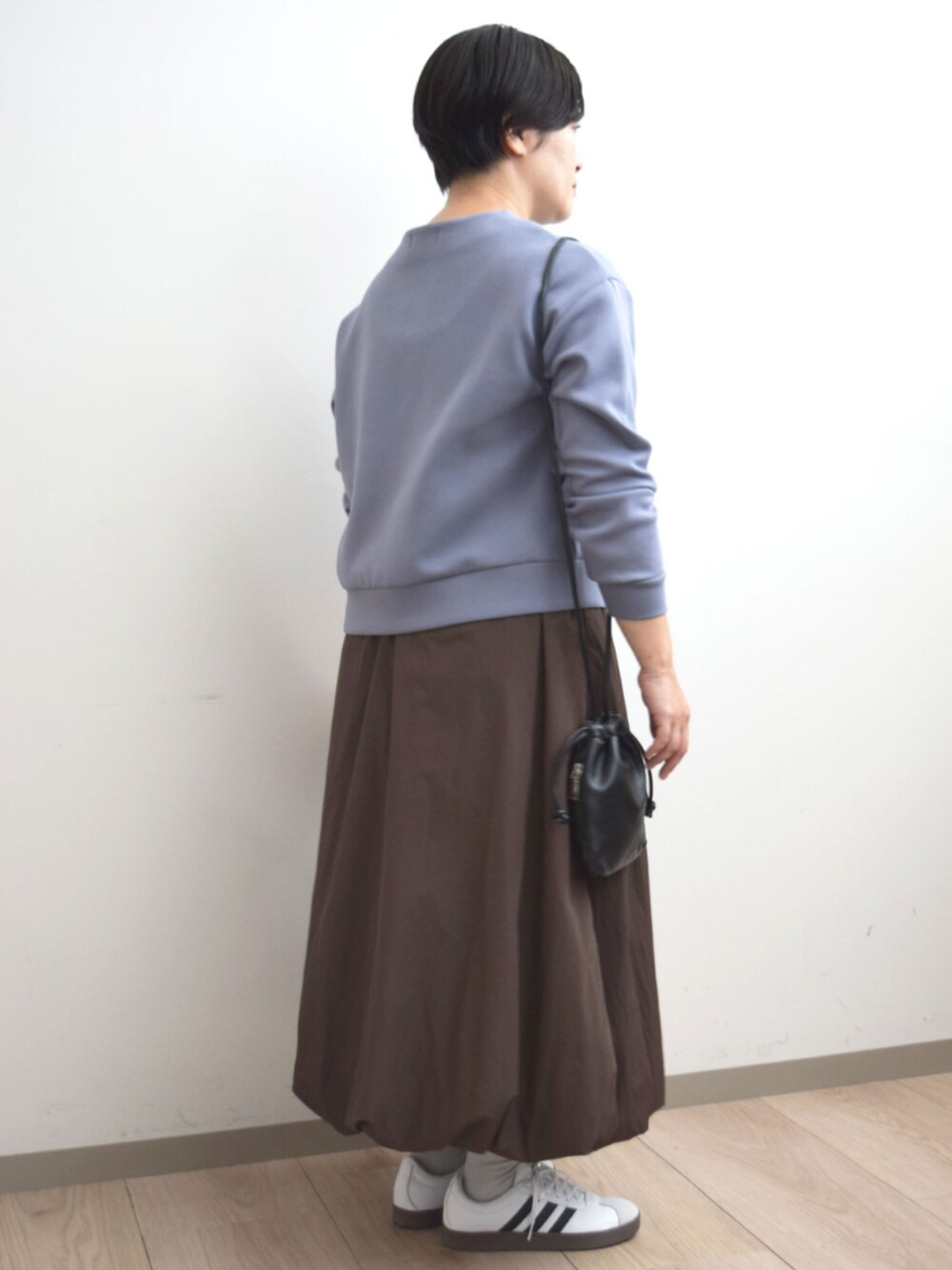 ブラウン系のスカート、ブルー系のスウェットを着用したレディースの秋コーディネートの3枚目の写真