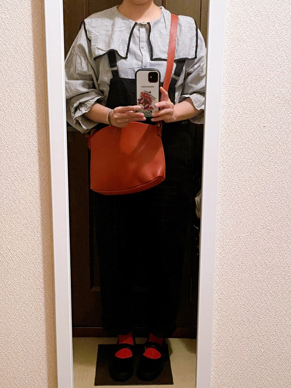 グレー系のシャツ/ブラウス、イエロー系のショルダーバッグ、ブラック系のサロペット/オーバーオールを着用したレディースの秋コーディネートの3枚目の写真