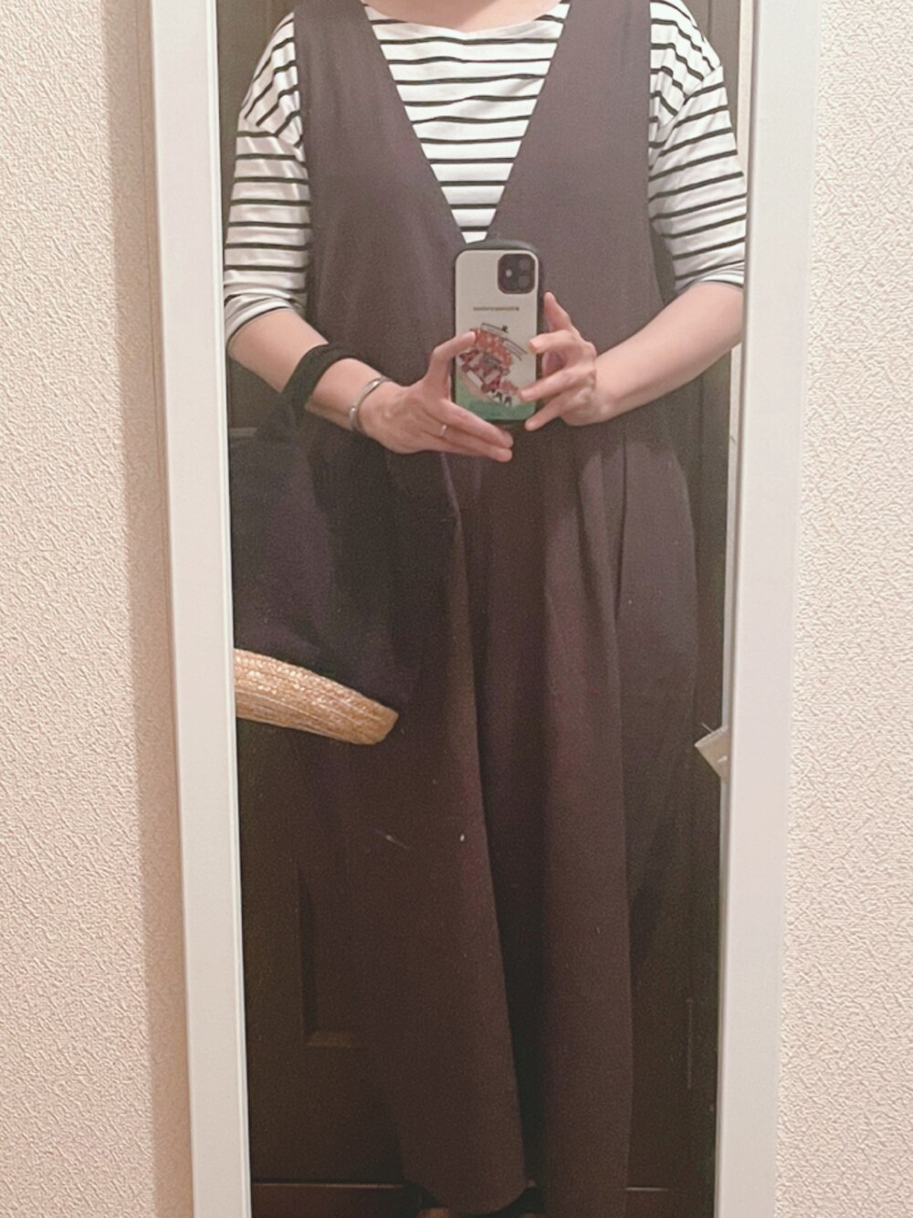 オレンジ系のTシャツ/カットソー、グレー系のサロペット/オーバーオール、ブラック系のサンダルを着用したレディースの夏コーディネートの2枚目の写真