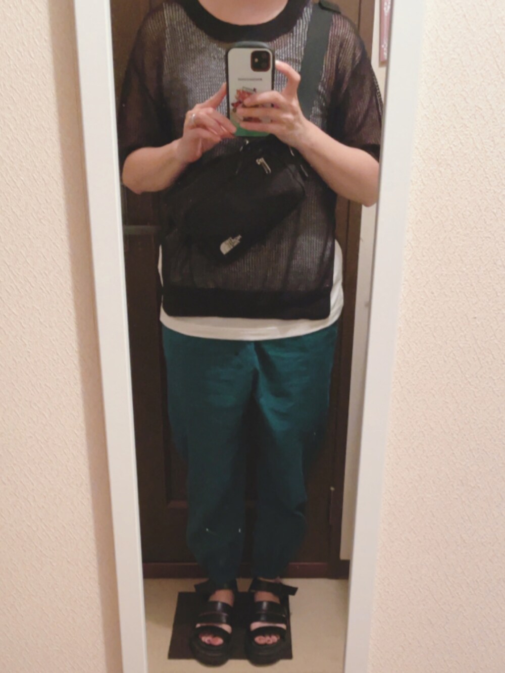 ブラック系のニット/セーター、ホワイト系のTシャツ/カットソー、ブラック系のボディバッグ/ウエストポーチを着用したレディースの夏コーディネートの2枚目の写真