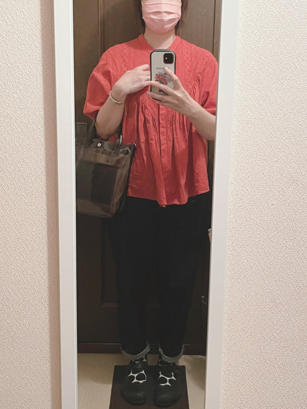 レッド系のシャツ/ブラウス、ブラック系のショルダーバッグ、ブルー系のデニムパンツを着用したレディースの夏コーディネートの2枚目の写真