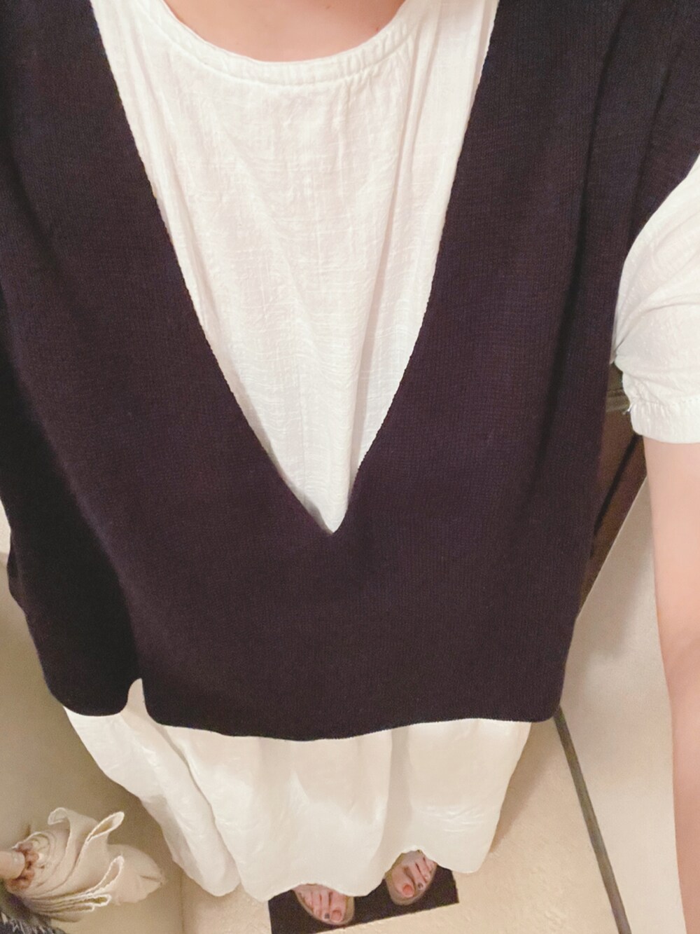 ブラック系のベスト、ホワイト系のワンピース、ベージュ系のサンダルを着用したレディースの夏コーディネートの4枚目の写真