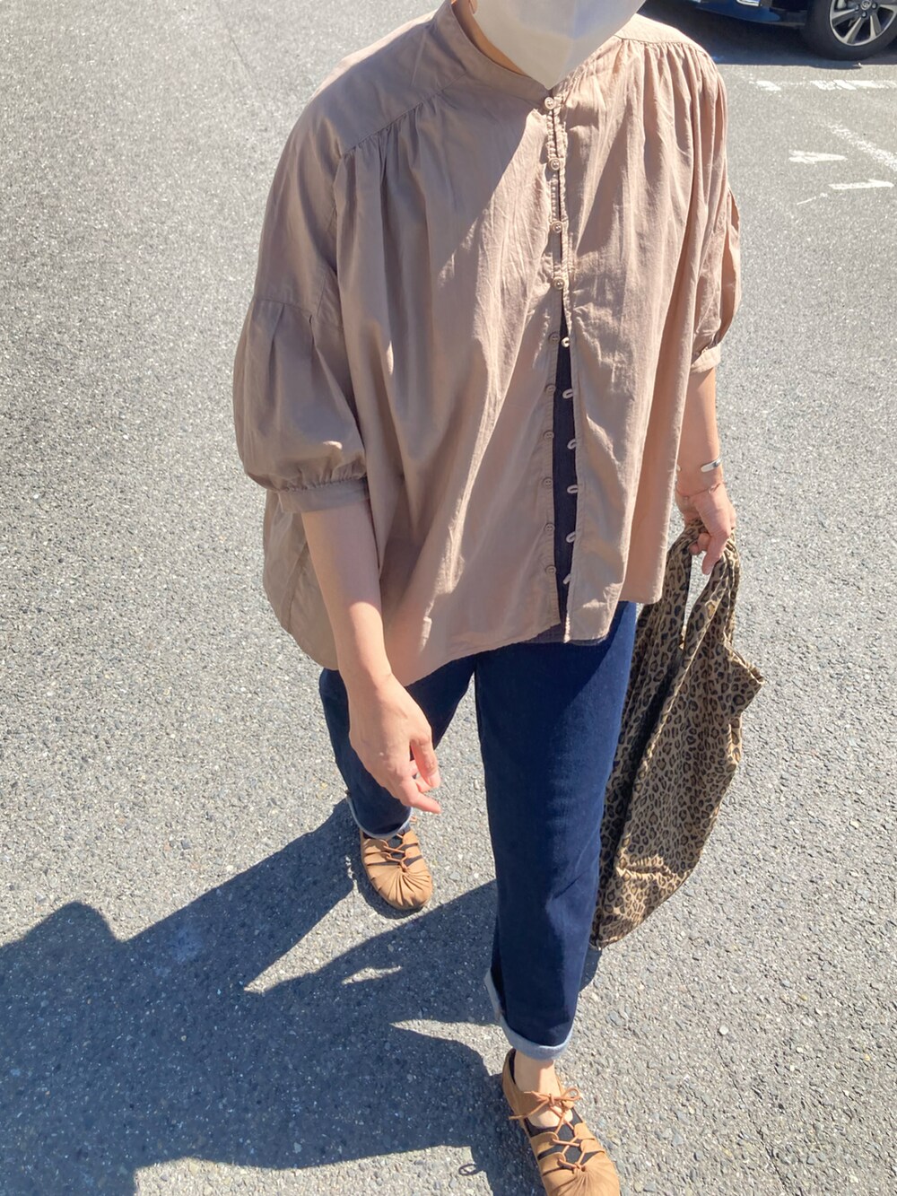 ベージュ系のシャツ/ブラウス、ベージュ系のトートバッグ、ブルー系のデニムパンツを着用したレディースの秋コーディネートの4枚目の写真