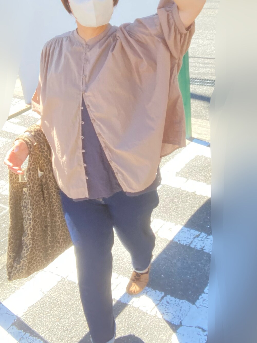 ベージュ系のシャツ/ブラウス、ベージュ系のトートバッグ、ブルー系のデニムパンツを着用したレディースの秋コーディネートの3枚目の写真