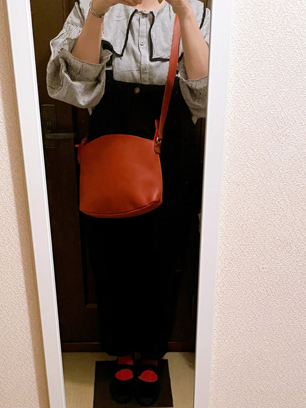 グレー系のシャツ/ブラウス、イエロー系のショルダーバッグ、ブラック系のサロペット/オーバーオールを着用したレディースの秋コーディネートの2枚目の写真