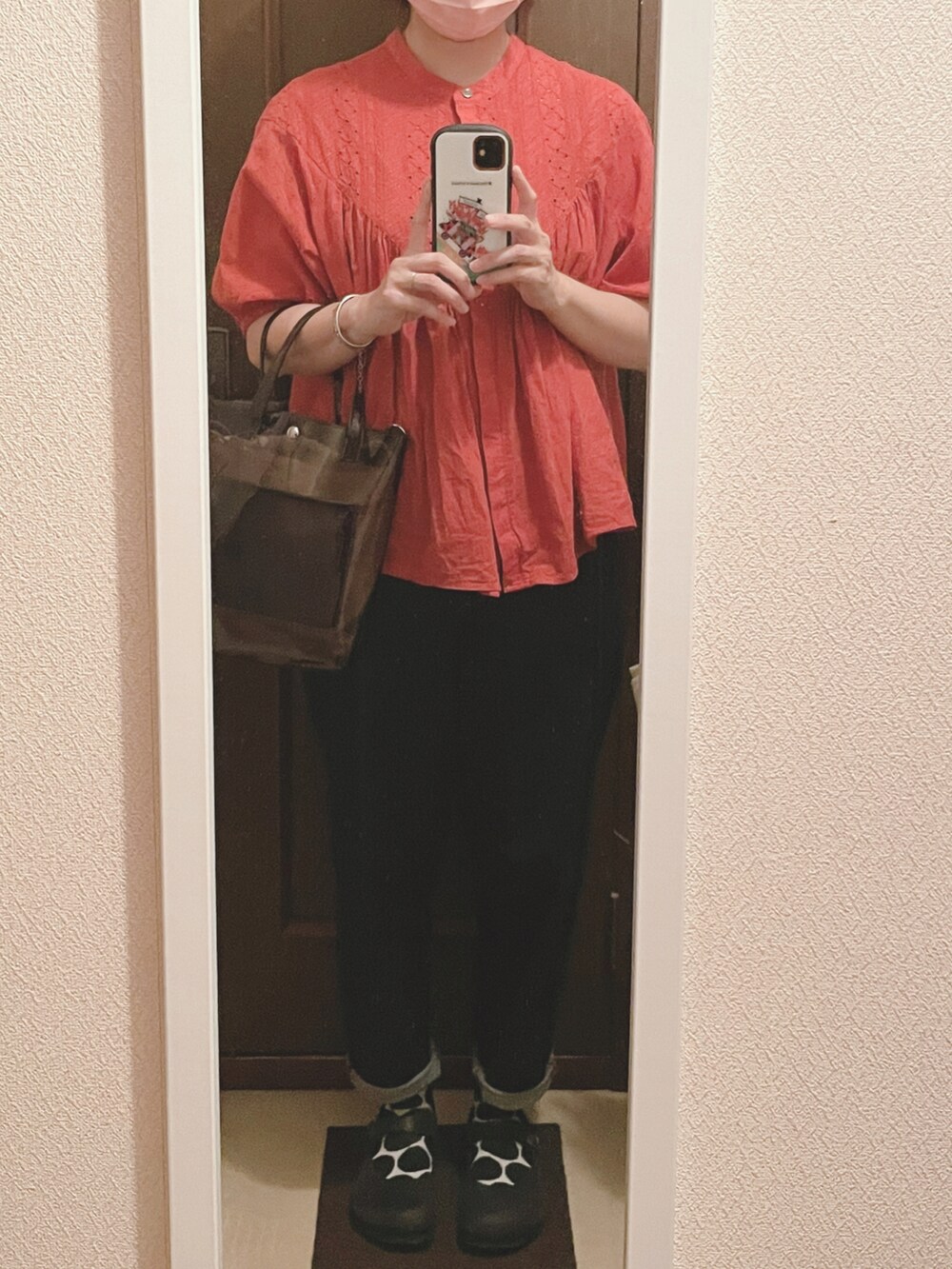 レッド系のシャツ/ブラウス、ブラック系のショルダーバッグ、ブルー系のデニムパンツを着用したレディースの夏コーディネートの3枚目の写真