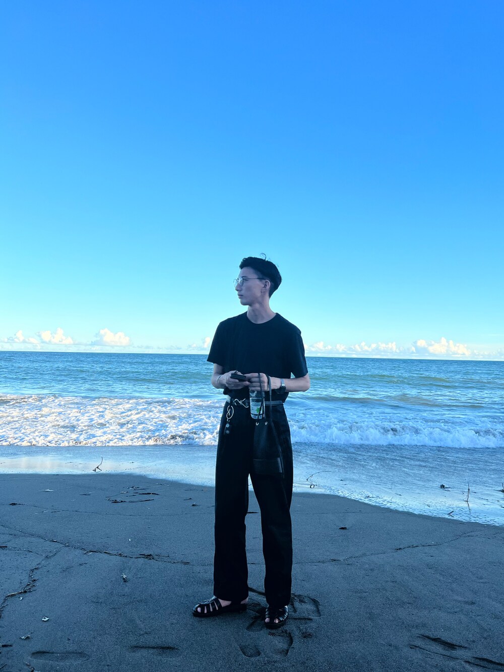 ブラック系のTシャツ/カットソー、ブルー系のその他パンツ、ブラック系のサンダルを着用したメンズの秋コーディネートの2枚目の写真