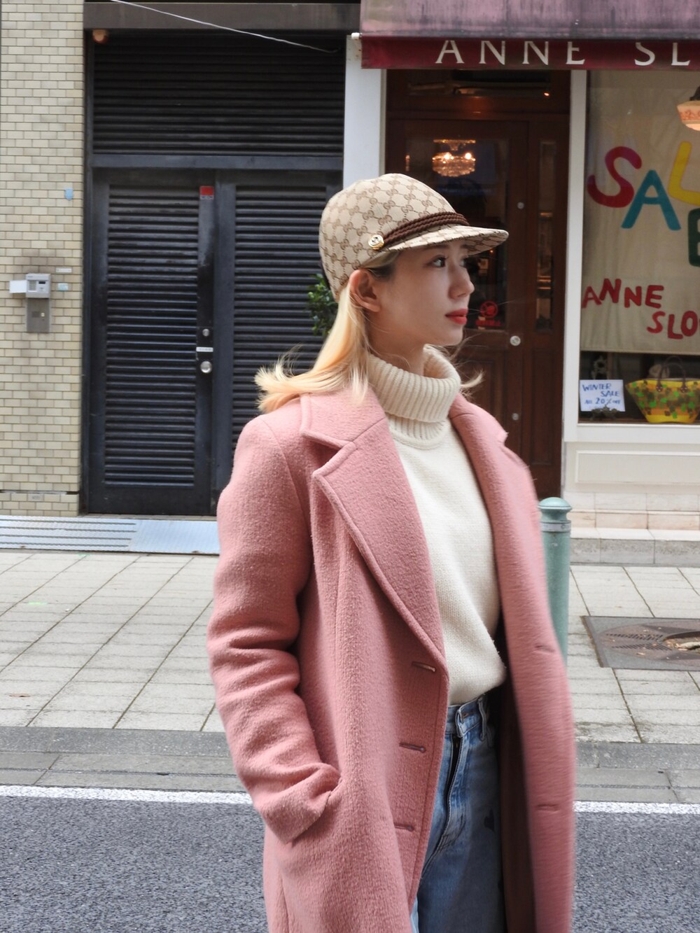 ブルー系のデニムパンツ、ピンク系のチェスターコート、ホワイト系のニット/セーターを着用したレディースの冬コーディネートの2枚目の写真