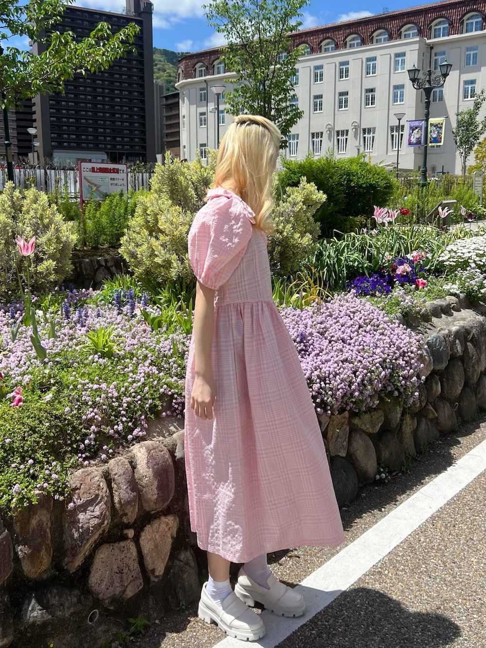 ピンク系のワンピース、ホワイト系のローファー、シルバー系のイヤリングを着用したレディースの春コーディネートの3枚目の写真