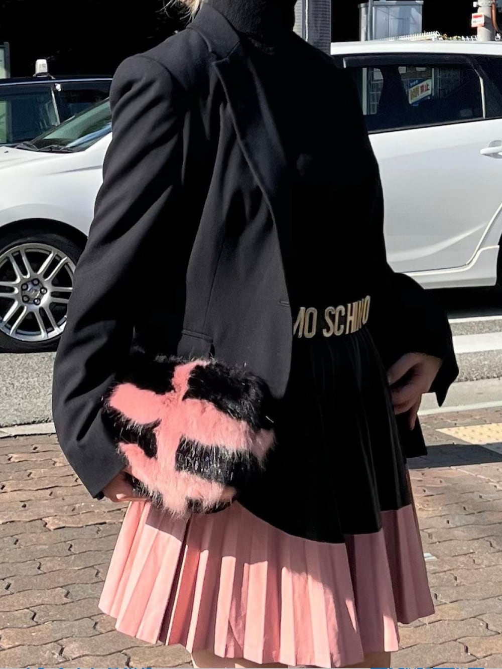 ブラック系のトップス、ブラック系のテーラードジャケット、ピンク系のスカートを着用したレディースの秋コーディネートの2枚目の写真