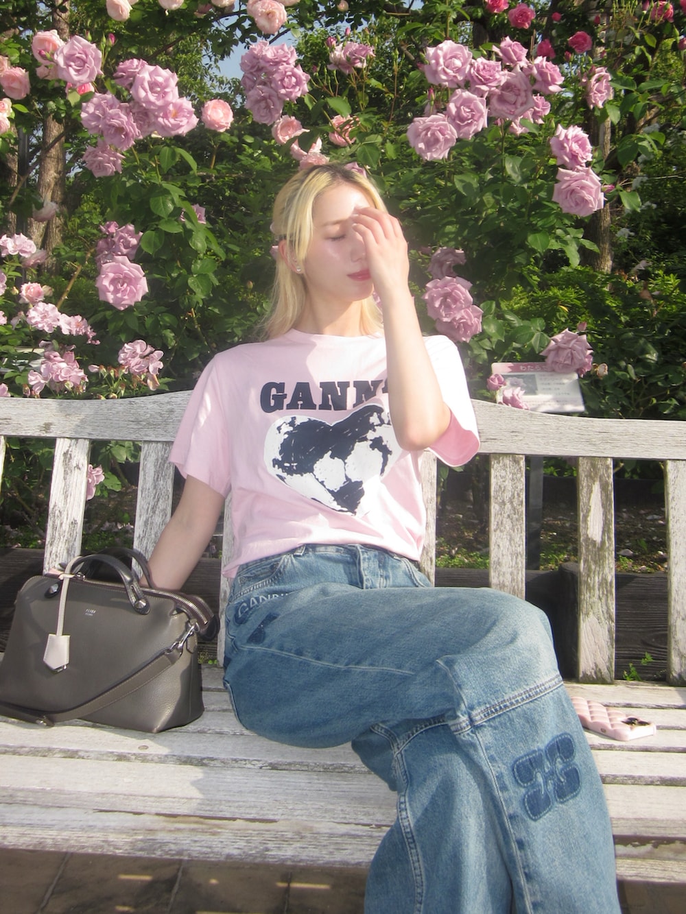 ブルー系のデニムパンツ、ピンク系のTシャツ/カットソー、グレー系のバッグを着用したレディースの春コーディネートの2枚目の写真