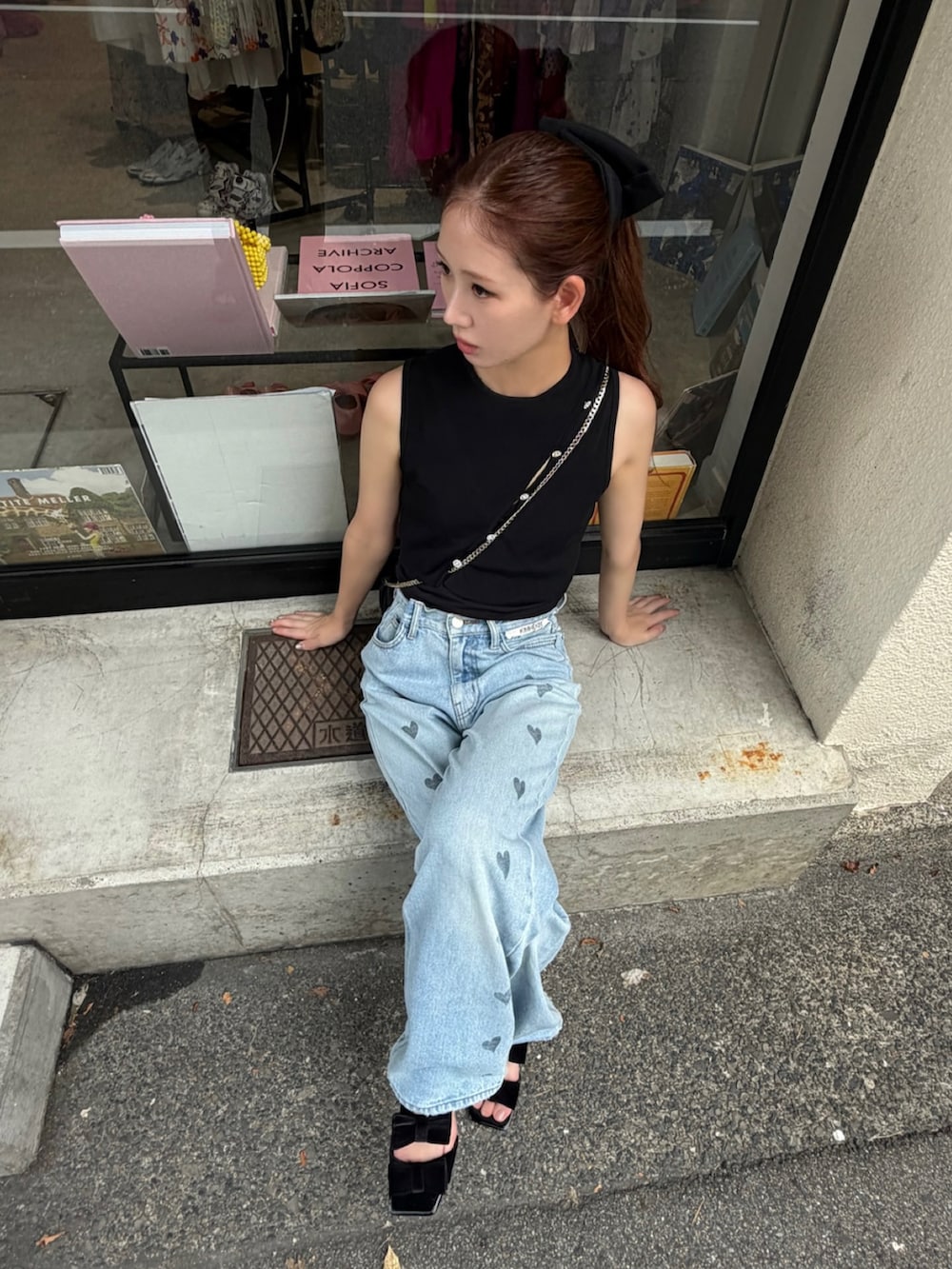 ブルー系のデニムパンツ、ブラック系のサンダル、ブラック系のトップスを着用したレディースの夏コーディネートの2枚目の写真