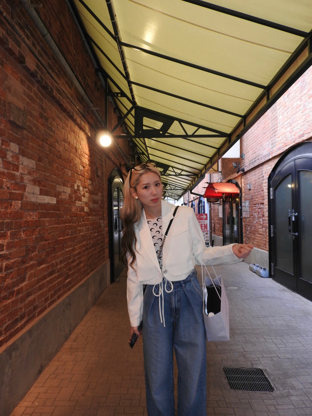 ホワイト系のその他トップス、ホワイト系のテーラードジャケット、ブラック系のブーツを着用したレディースの春コーディネートの2枚目の写真