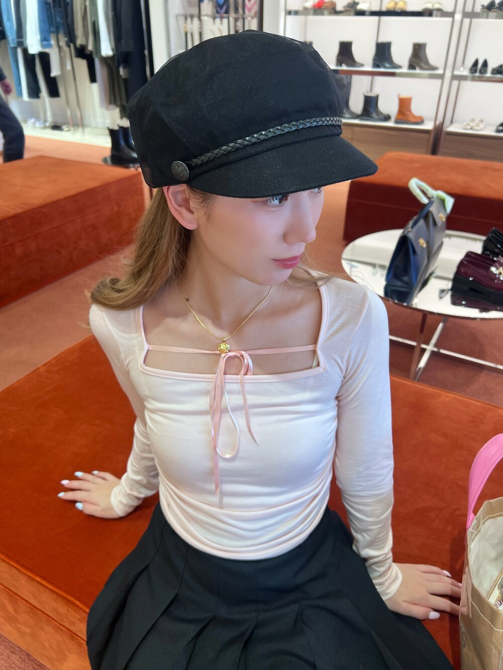 ピンク系のトップス、ブラック系のスカート、ブラック系のキャスケットを着用したレディースの冬コーディネートの2枚目の写真