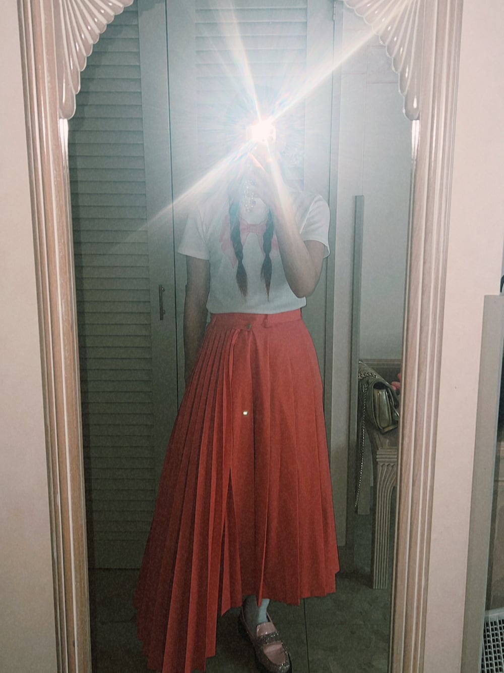 ピンク系のスカート、ホワイト系のTシャツ/カットソー、ピンク系のローファーを着用したレディースの夏コーディネートの2枚目の写真