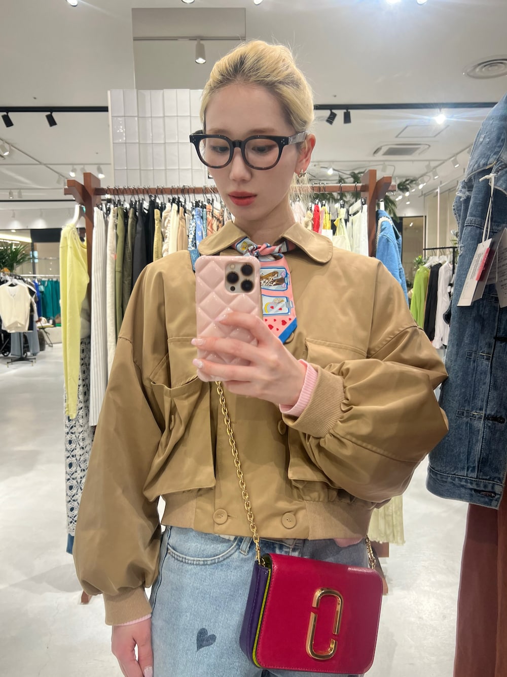 ブルー系のデニムパンツ、ブラック系のブーツ、ベージュ系のトレンチコートを着用したレディースの春コーディネートの2枚目の写真