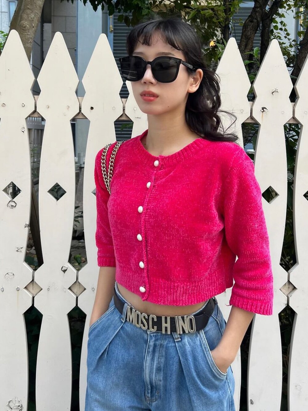 ピンク系のカーディガン/ボレロ、ブルー系のデニムパンツ、ブラック系のサングラスを着用したレディースの秋コーディネートの4枚目の写真